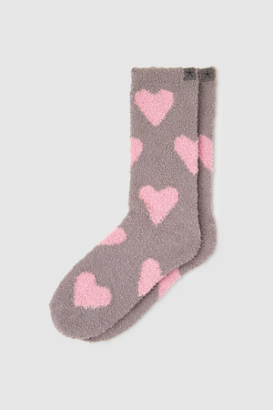Gray socks with pink heart patterns on a light gray background