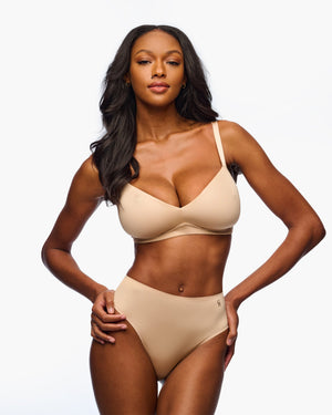 Woman wearing a beige bra on a white background