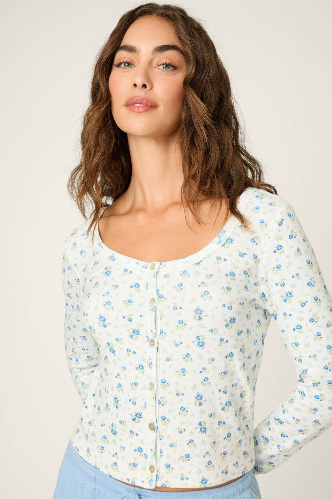Woman wearing a floral blouse against a plain background