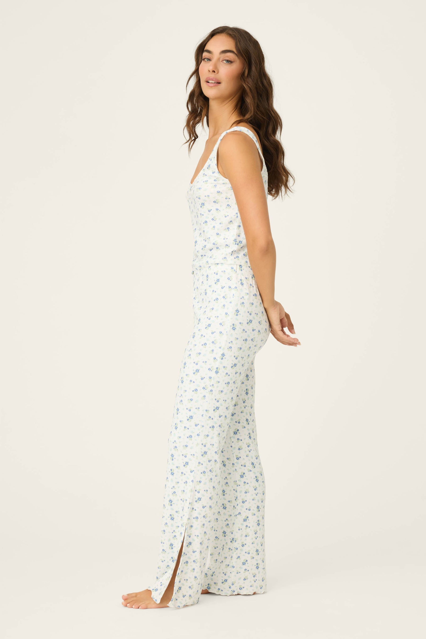 Woman wearing a white floral pants on a plain background